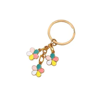 Gold metal keychain featuring three colorful enamel flower pendants on a white background