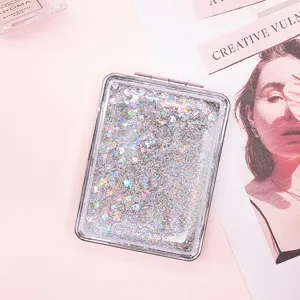 Close-up of portable rectangular quicksand mirror with sparkling silver glitter.