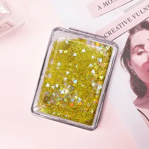 Close-up of portable folding quicksand makeup mirror with yellow glitter and heart sequins