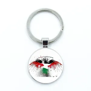 Detail view of Palestine flag keychain featuring a bird graphic and brotherly slogan