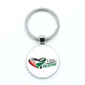Close-up of circular Palestine flag keychain featuring a heart-shaped anti-war design.