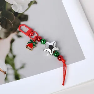 Nahaufnahme eines festlichen Weihnachts-Taschenanhängers mit Sternperlen und einer roten Glocke