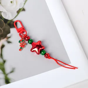 Detailansicht eines süßen Weihnachtsanhängers mit rotem Stern und Zuckerstangen-Charms