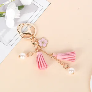 Close-up of pink cherry blossom keychain with soft tassels and white pearls