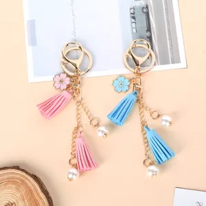 Detail of cute pink and blue keychains with tassels, cherry blossoms, and pearls