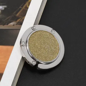 Detailaufnahme eines kreisförmigen goldenen Glitzer-Taschenhakens mit poliertem Silbermetall