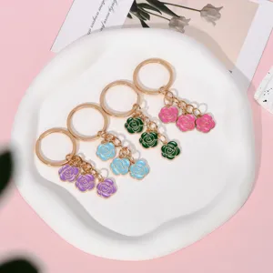 Detailed macro view of colorful enamel rose flower charms on golden metal keychains