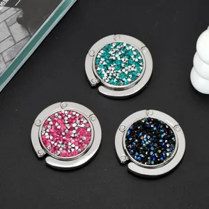 Bovenaanzicht van sprankelende opvouwbare handtashaken met roze, blauwe en zwarte strass.