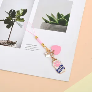 Close-up view of a cute pink cat paw phone strap featuring heart and star pendant charms