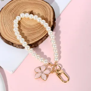 Elegant white pearl bead keychain with pink flower pendant and gold hardware.