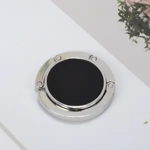 Draagbare opvouwbare zilveren en zwarte ronde tassenhaak voor tafels, minimalistisch design