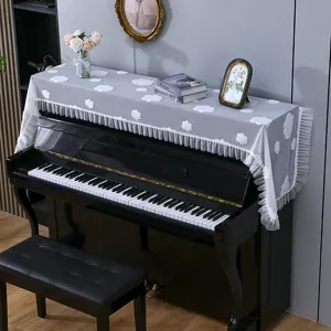 Housse anti-poussière pour piano avec motif de nuage blanc et élégants volants en dentelle.
