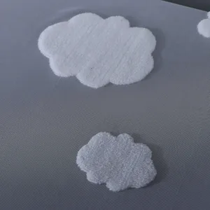 Housse de piano en maille grise avec jolie broderie de nuages blancs pour deco moderne.