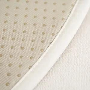 Detailopname van antislip onderkant van stoelkussen met noppen en nette randafwerking.