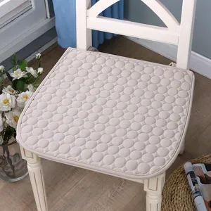 Gros plan détaillé du coussin de chaise matelassé beige avec motif rond dans la scène.