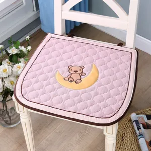 Vue détaillée du coussin de chaise matelassé rose avec broderie d'ours, doux et confortable.
