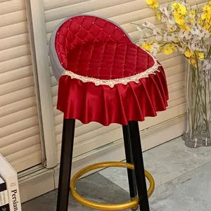 Détail de housse de tabouret de bar matelassée rouge avec élégant volant en dentelle.