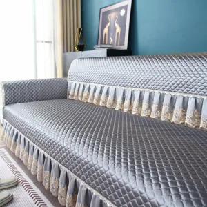 Quilted gray sofa cover with elegant lace frills, thickened non-slip living room protector.