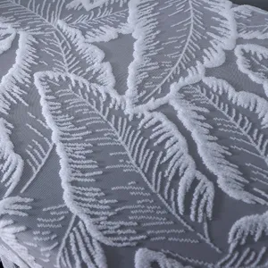 Vue détaillée du tissu de housse de piano blanc avec broderie élégante de feuilles en relief.