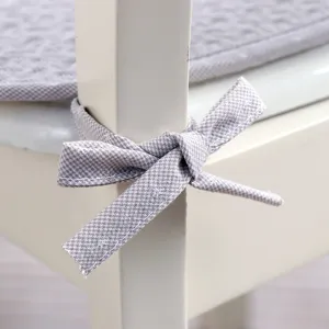 Close-up detail of grey checkered chair cushion tie, soft fabric and neat stitching for decor.
