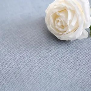 Detailweergave van de zachte grijze gewatteerde kussentof textuur met elegante witte roos.