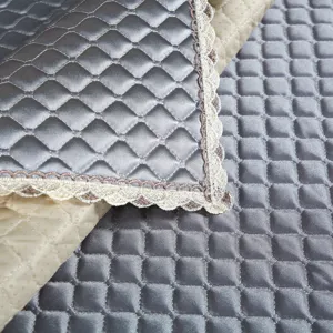 Quilted sofa cushion cover detail, thickened diamond pattern with elegant lace edge fabric.
