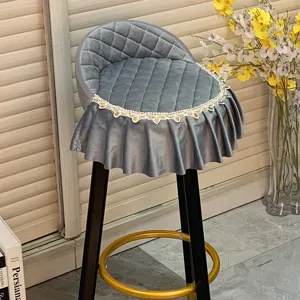Vue détaillée d'une housse de tabouret de bar en velours gris avec matelassage et dentelle.