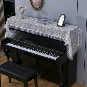 Vue détaillée de l'élégante housse de protection en dentelle pour piano avec motif de feuilles.