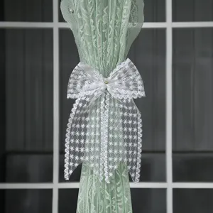 Gros plan détaillé d'un élégant nœud en dentelle blanche avec perle pour embrasse rideau.