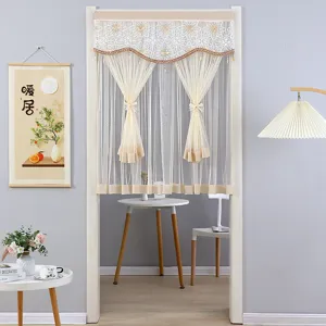 Detailed view of white lace door curtain with delicate embroidery and elegant tassels.