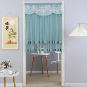 Detail view of teal lace half door curtain with intricate embroidery and beaded fringe design.