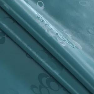 Primo piano del tessuto per tovaglia impermeabile verde teal con motivo in rilievo.