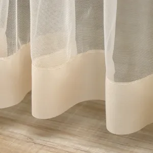 Detail close-up of beige mesh lace curtain hem with satin border, showcasing fine fabric.