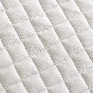 Close-up view of quilted fabric texture with grid stitching, soft velvet material detail for chair cushion.