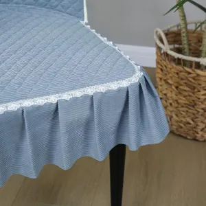 Blue quilted chair cover detail, elegant white lace trim and pleated skirt design.