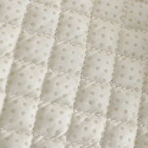 Detailed view of quilted chair cushion fabric with elegant polka dots and soft texture.