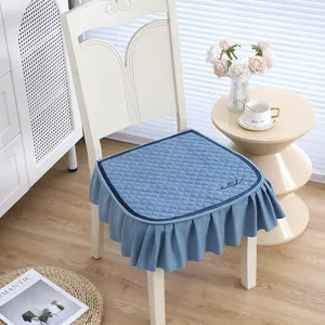Detailed view of the blue quilted dining chair cushion featuring an elegant ruffled skirt design.