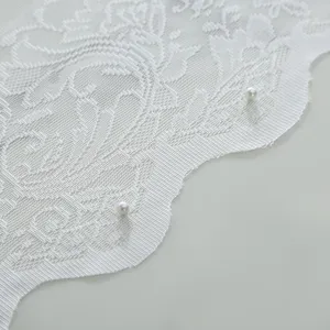 Close up of white floral lace fabric detail with elegant scalloped edges and pearl pins.