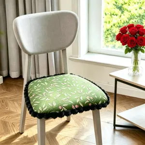 Detailed view of green botanical print memory foam chair cushion with plush black trim for office.