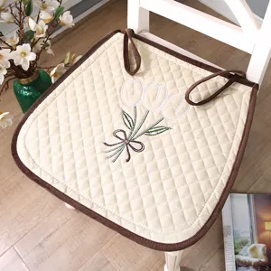Quilted dining chair cushion with embroidered tulip design and brown piping for home office.