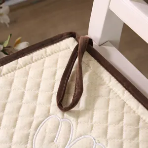 Detailed view of the quilted chair cushion with brown binding and soft fabric for office and home.