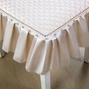 Vue détaillée de la housse de chaise de salle à manger matelassée avec élégante bordure en dentelle.