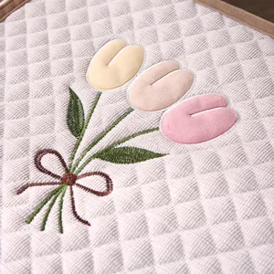 Quilted chair cushion detail, embroidered tulip design, thick comfortable seat pad for office home.