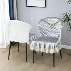 Vue détaillée de la luxueuse housse de chaise matelassée avec jolie bordure en dentelle.