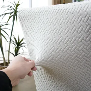 Gros plan detaille montrant la texture elastique de la housse de chaise jacquard blanche.