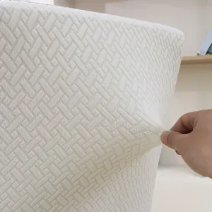 Detailed shot showing the elastic texture and stretchable fabric of the white chair slipcover.