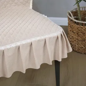 Housse de chaise matelassée beige détail avec fine bordure en dentelle et jupe plissée.