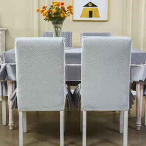 Vue détaillée de la housse de chaise de salle à manger grise texturée avec jupe intégrée.