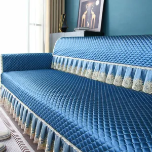 Blue quilted sofa cover with elegant lace skirt trim, thickened four-season home decor slipcover.