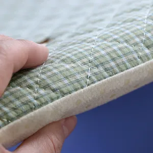 Détail de coussin d'étudiant épaissi avec tissu à carreaux verts, matelassage et dos antidérapant.